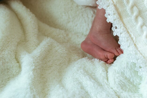 Infant feet in white clothes