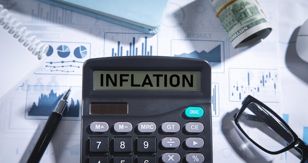 Inflation on calculator with a pen and eyeglasses