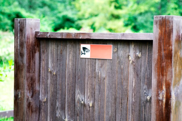 Information board made of wood in the park, with a video surveillance icon.