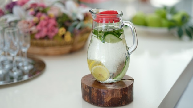 Infused detox water with cucumber lemon and mint in jug on table