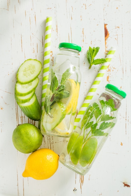 Infused water with citrus and herb in glass bottle