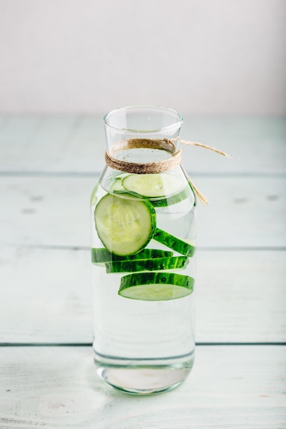 Infused water with sliced cucumber in bottle