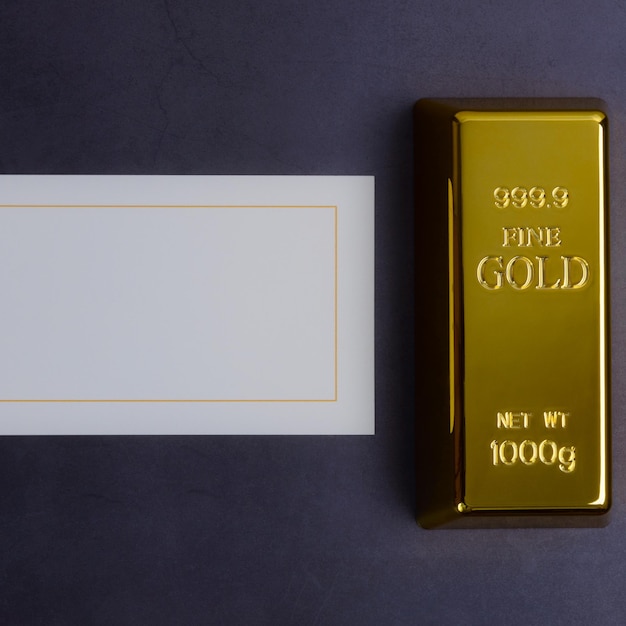 An ingot of gold metal bullion of pure brilliant on a gray textured background