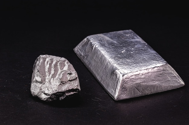 Ingot and metal bar next to metal ore, material used in general industry