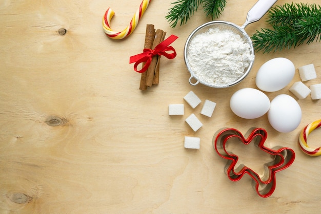 Ingredients for baking christmas gingerbread cookies. Flour, eggs and sugar on wooden background, copyspace.