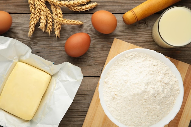 Ingredients for baking or cooking egg flour rolling pin butter milk on a grey wooden background Cookie pie or cake recipe