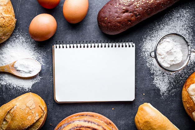 Ingredients baking for flour and rye bakery products. Fresh crisp bread, baguette, buns on a black chalkboard background.