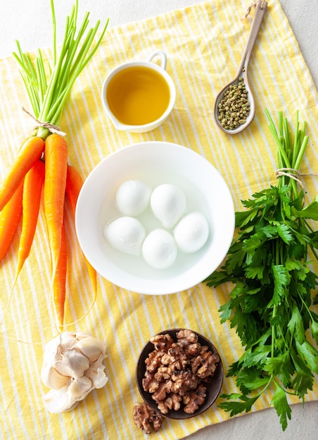 Ingredients for a carrot, eggs, oil, oil, and oil on a yellow towel.