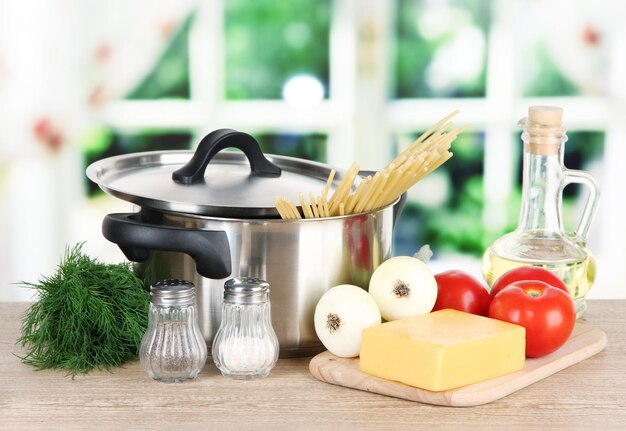 Ingredients for cooking pasta on table in kitchen