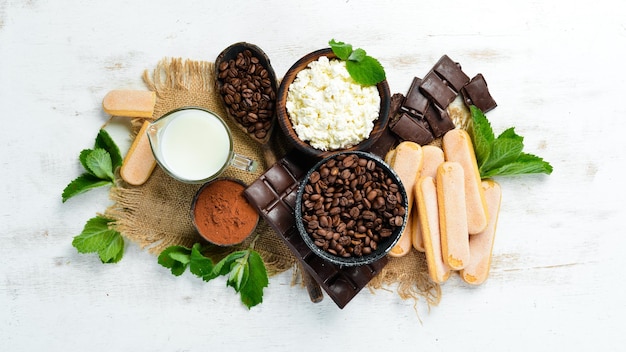 Ingredients for dessert tiramisu on a white wooden background