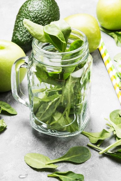 Ingredients for green smoothie - apples, spinach, celery, avocado on a light background