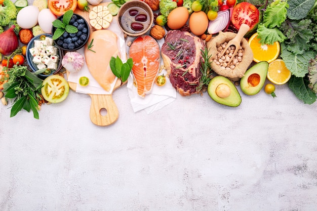 Ingredients for healthy foods selection set up on white concrete