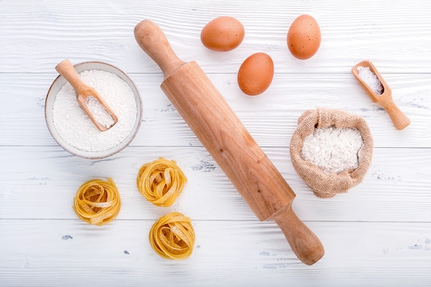 Ingredients for homemade pasta  flour and eggs on wooden background.