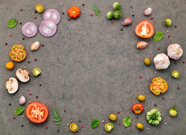 The ingredients for homemade pizza set up on dark stone background.