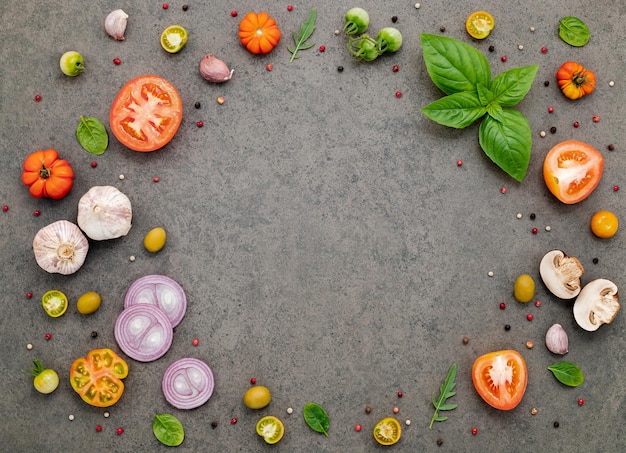 The ingredients for homemade pizza set up on dark stone background