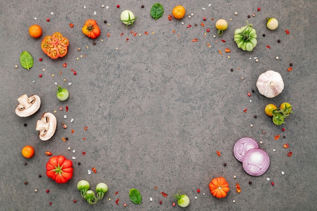 The ingredients for homemade pizza set up on dark stone background