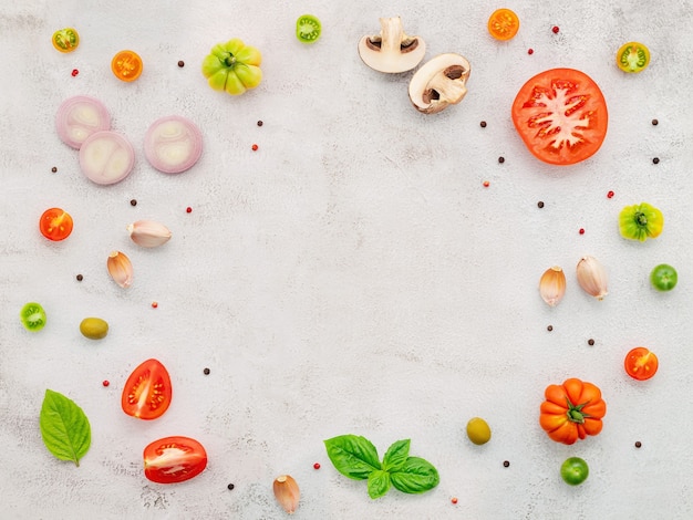 The ingredients for homemade pizza set up on white concrete background.