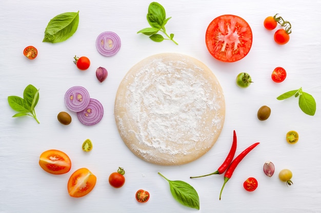 The ingredients for homemade pizza on white wooden background.