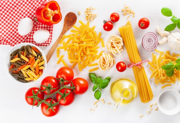 Ingredients for italian cousine flat lay, pasta spaghetti penne fusilli tomato oil vegetables