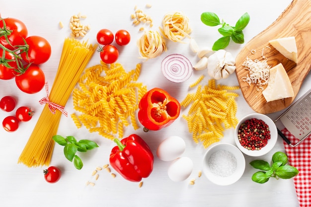 Ingredients for italian cousine flat lay, pasta spaghetti penne fusilli tomato oil vegetables