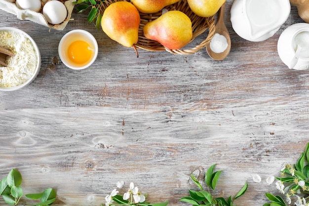 Ingredients for making buns or pies with jam and fresh pears on a wooden background Top view Copy Space