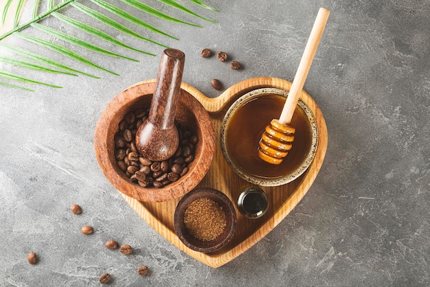 Ingredients for making homemade coffee skincare scrub on a heart shaped plate