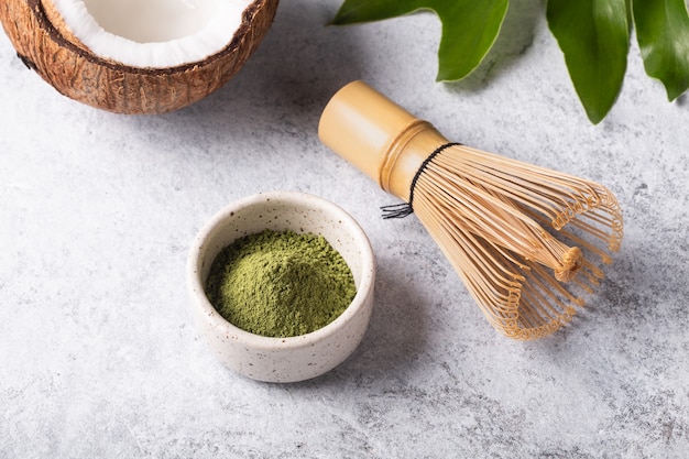 Ingredients for making matcha latte, Japanese green tea with coconut milk on white background.