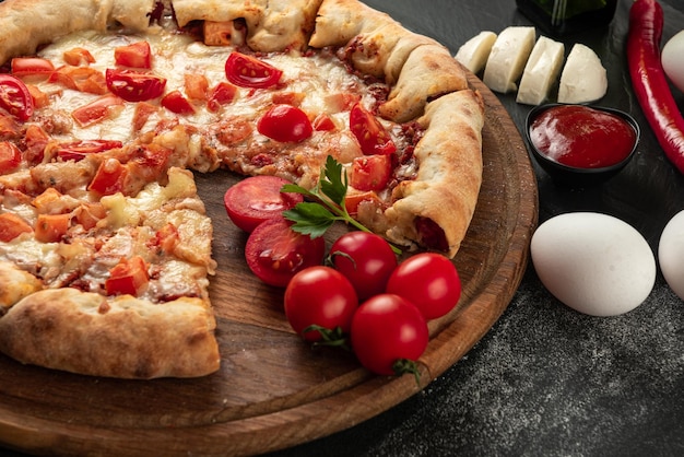 Ingredients for the pizza on a dark background indian pizza with tomatoes and peppers close up view