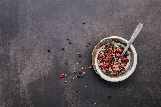 Ingredients for steak seasoning in ceramic bowl set up on dark concrete background with copy space