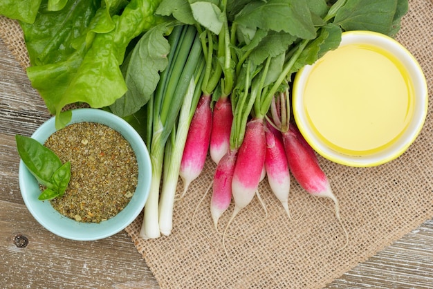 Ingredients on the table raddish lettuce onion oil and oregano