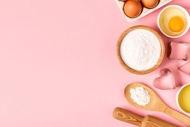 Ingredients and utensils for baking on a pastel background, top view.