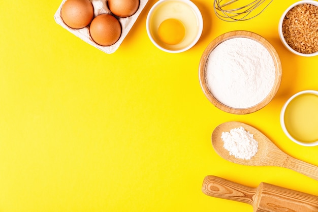 Ingredients and utensils for baking on a pastel background, top view.