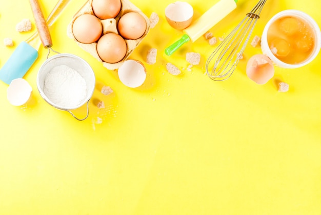 Ingredients and utensils for cooking baking egg, flour, sugar, whisk, rolling pin