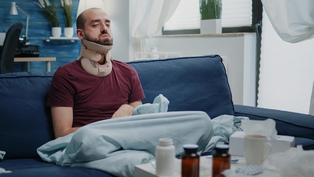 Injured man wearing cervical neck collar against muscle pain