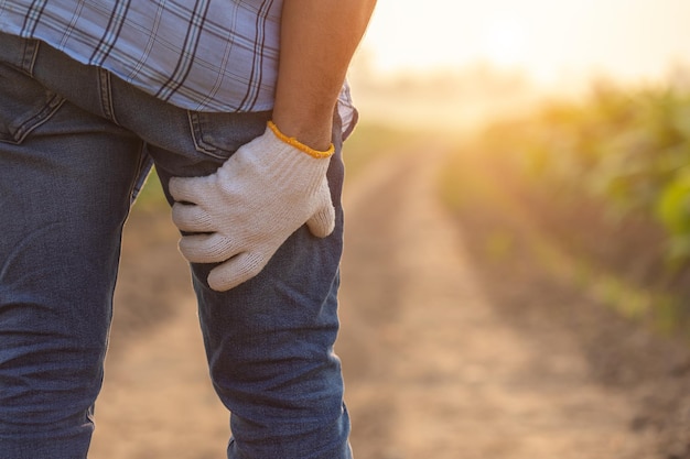 Injuries or Illnesses that can happen to farmers while working Man is using his hand to cover over Calf because of hurt pain or feeling ill