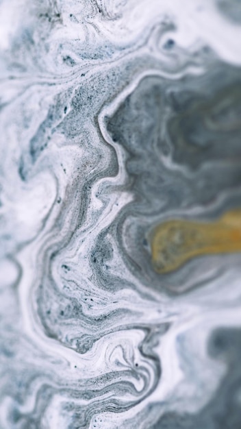 Ink fluid mix marble texture defocused white gray color golden sand particles pigment powder acrylic