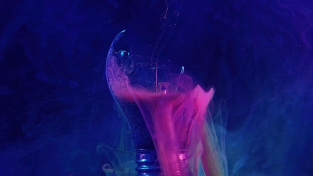 Ink water drop broken light bulb fantasy energy neon pink blue color smoke haze floating in cracked