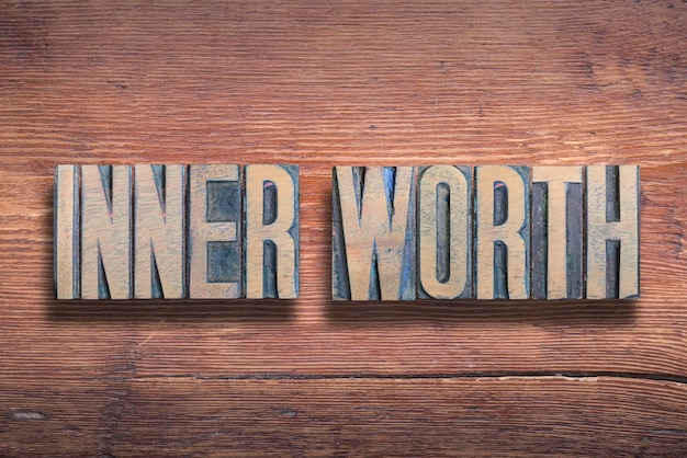 Inner worth phrase combined on vintage varnished wooden surface