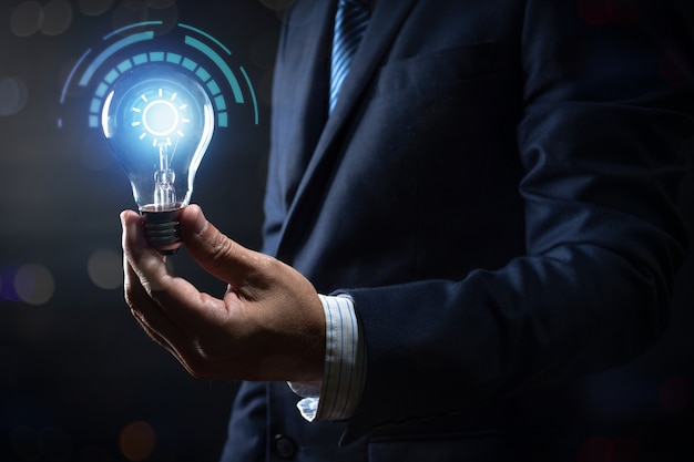 Innovation and energy of creative thinking, businessman holding light light bulb glowing and lighting with connection