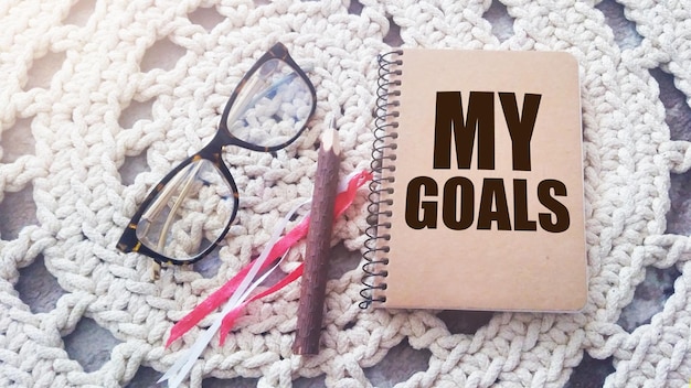 Photo inscription in copybook my goals pen glasses notebook business concept