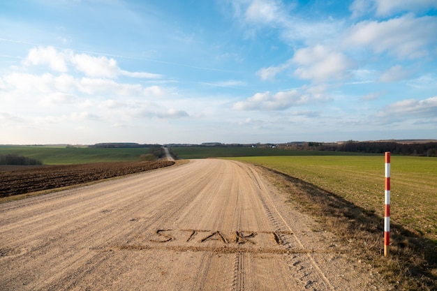 Inscription on a dirt road the words start