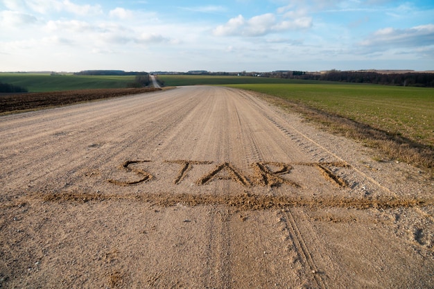 Inscription on a dirt road the words start