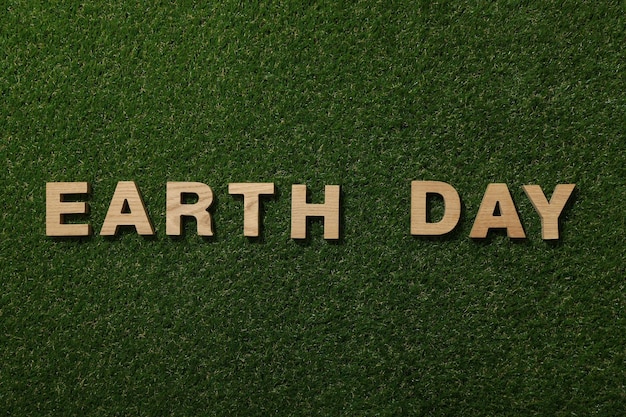 The inscription Earth Day in wooden letters on the grass