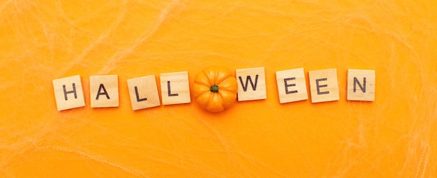 The inscription halloween sale with little pumpkin on orange background with spider web banner