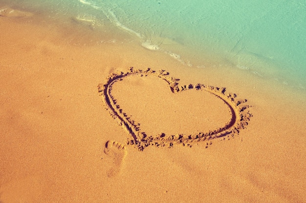 Photo inscription heart on beach sand