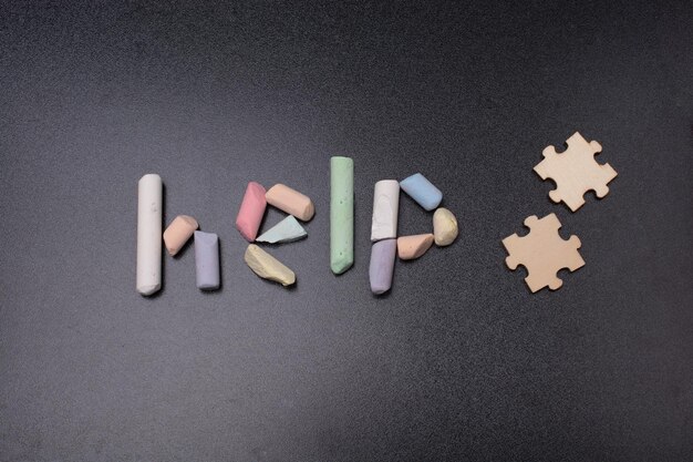 The inscription on the help of colored chalk by puzzle pieces