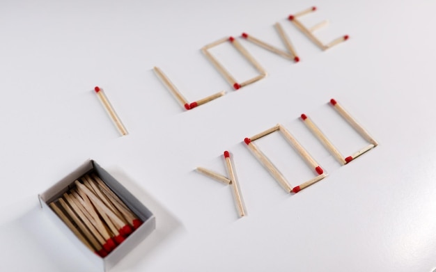 Photo the inscription i love you is lined with matches next to the box macro wallpaper