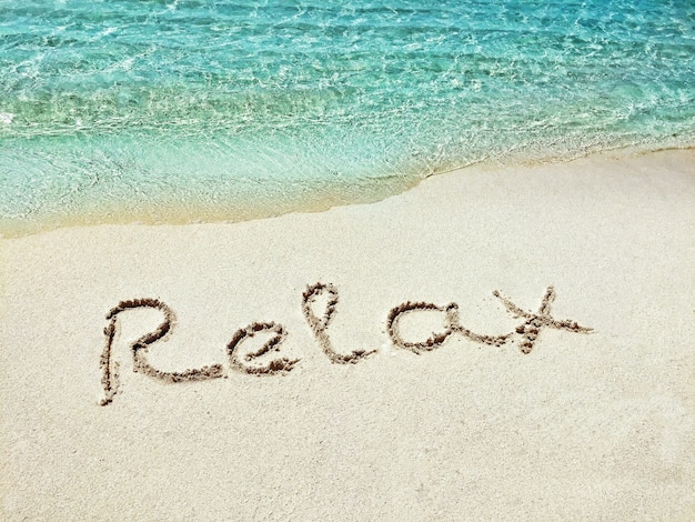 Inscription "Relax" in the sand on a tropical island,  Maldives.