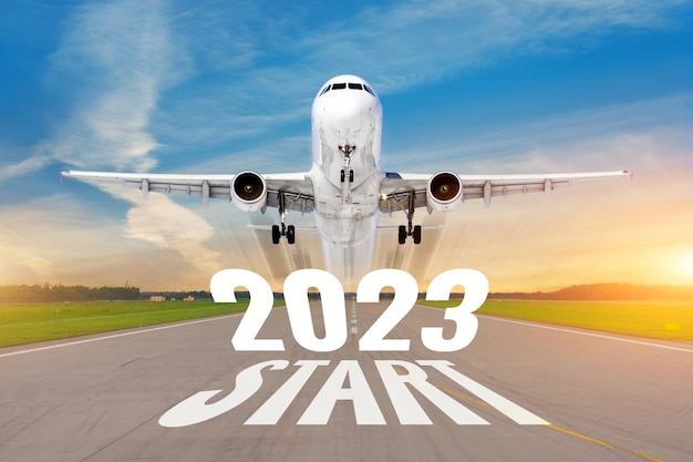 Inscription on the runway start 2023 surface of the airport road line rapidly taking off aircraft Concept of travel in the new year holidays