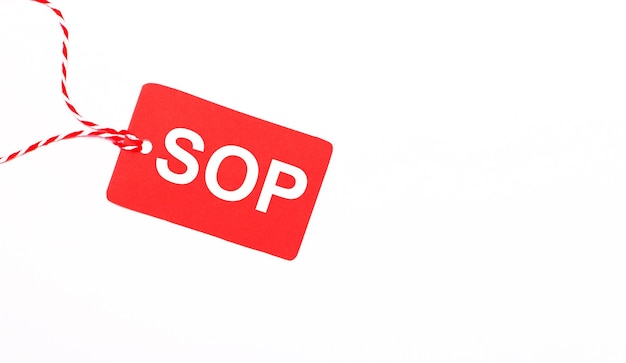 The inscription SOP Standard Operating Procedure on a red price tag on a light background Advertising concept Copy space